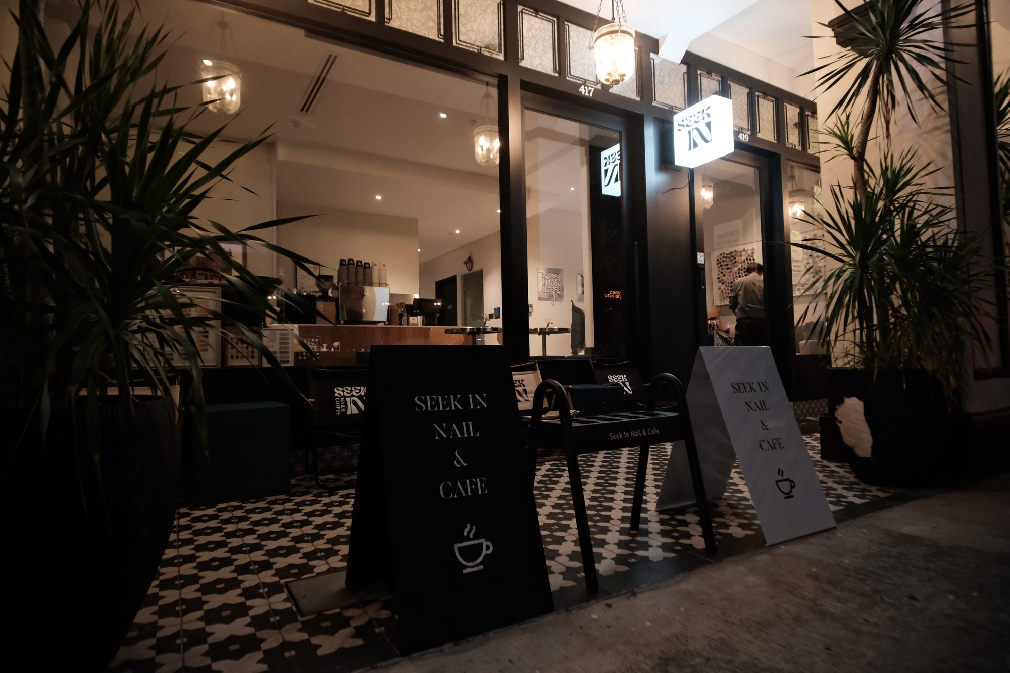 Raised timber manicure platform with nail stations in a compact café Singapore